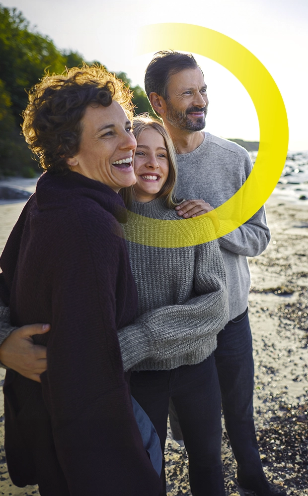 Famiglia che guarda l'orizzonte al mare