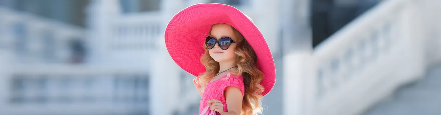 Bambina con cappello fucsia e occhiali da sole